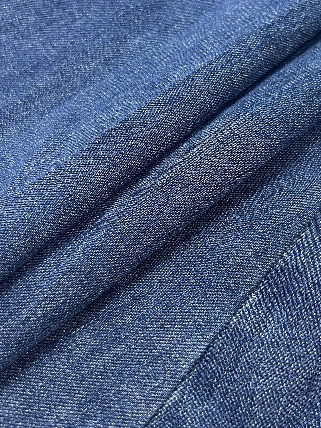 Cotton stretchable denim dress fabric close-up in blue with textured weave