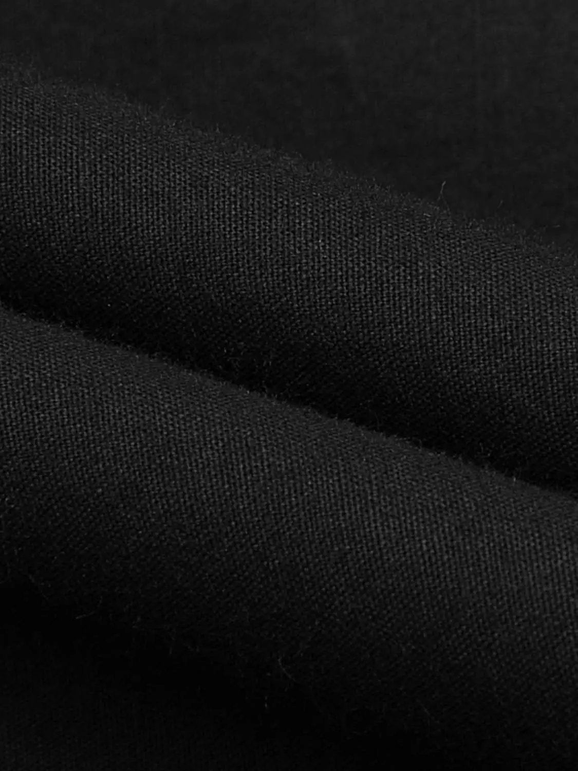 A-line cotton skirt fabric in black; close-up woven texture.