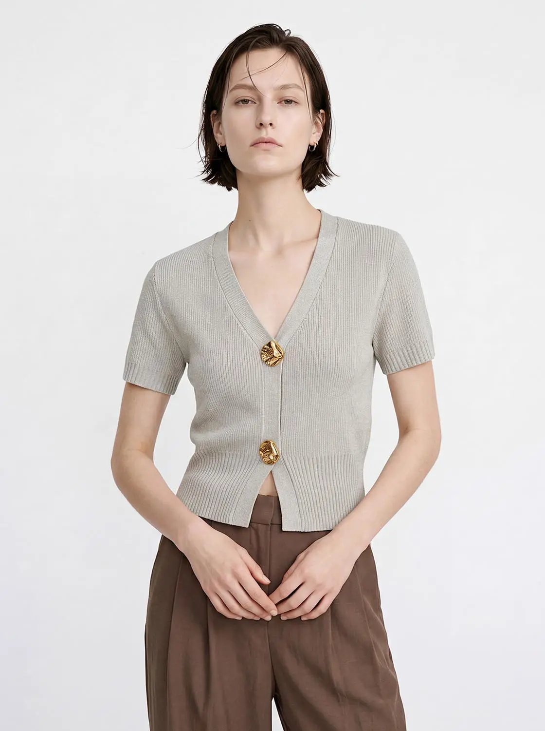 Women's short-sleeve light gray knitted cardigan with V-neck and cropped hem, gold-tone buttons.