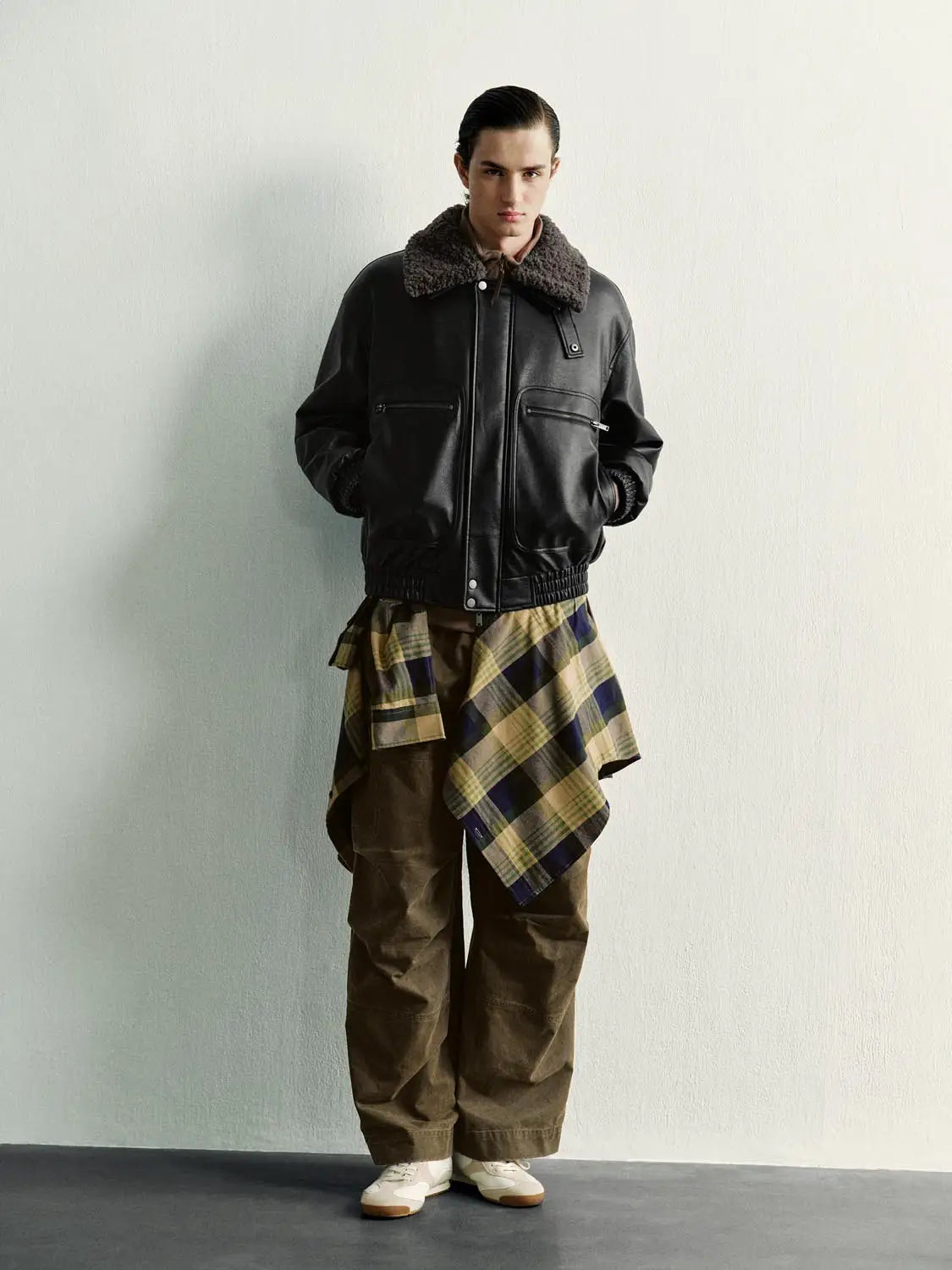 Urban Revivo padded jacket in black leather-look with a shearling collar and zip pockets on a male model.