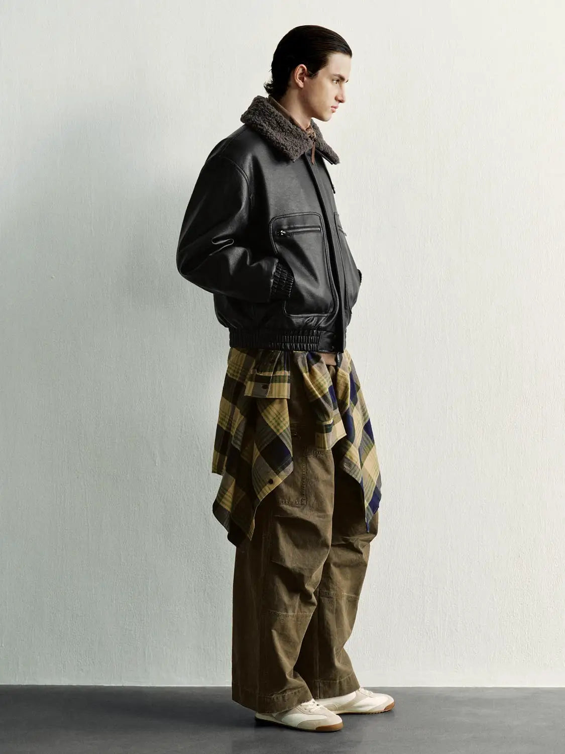 Padded jacket in black with brown shearling collar, paired with plaid shirt and cargo pants