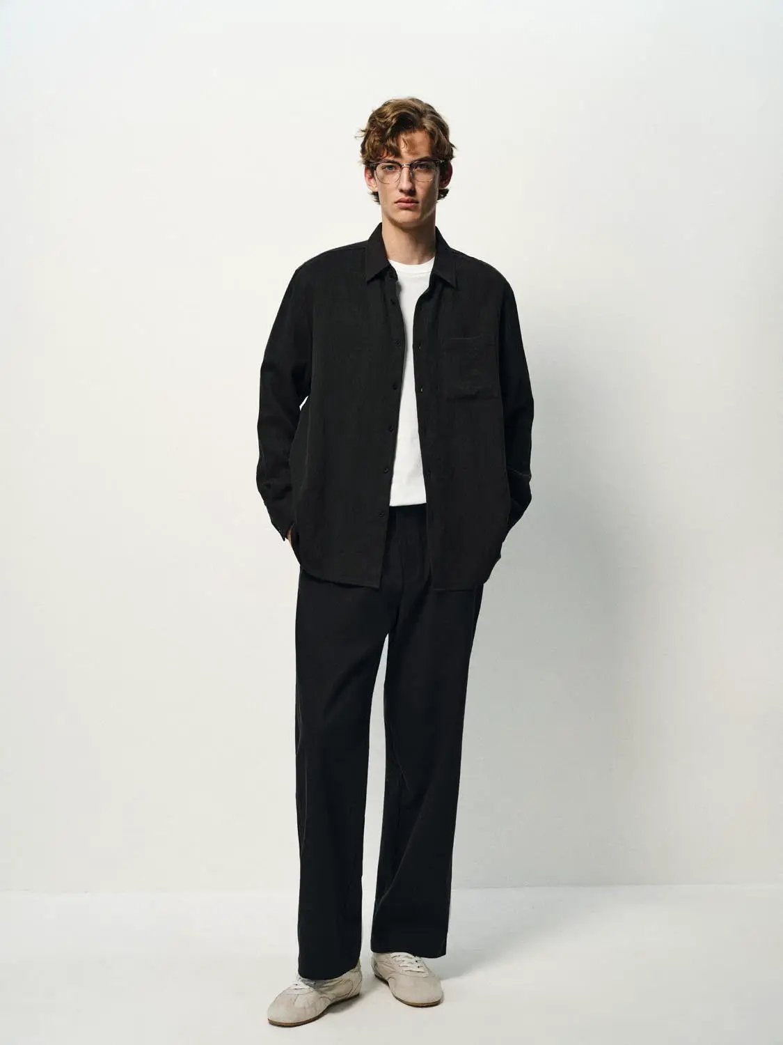 Cardigan shirt in black with button-front and chest pocket, worn over a white tee.