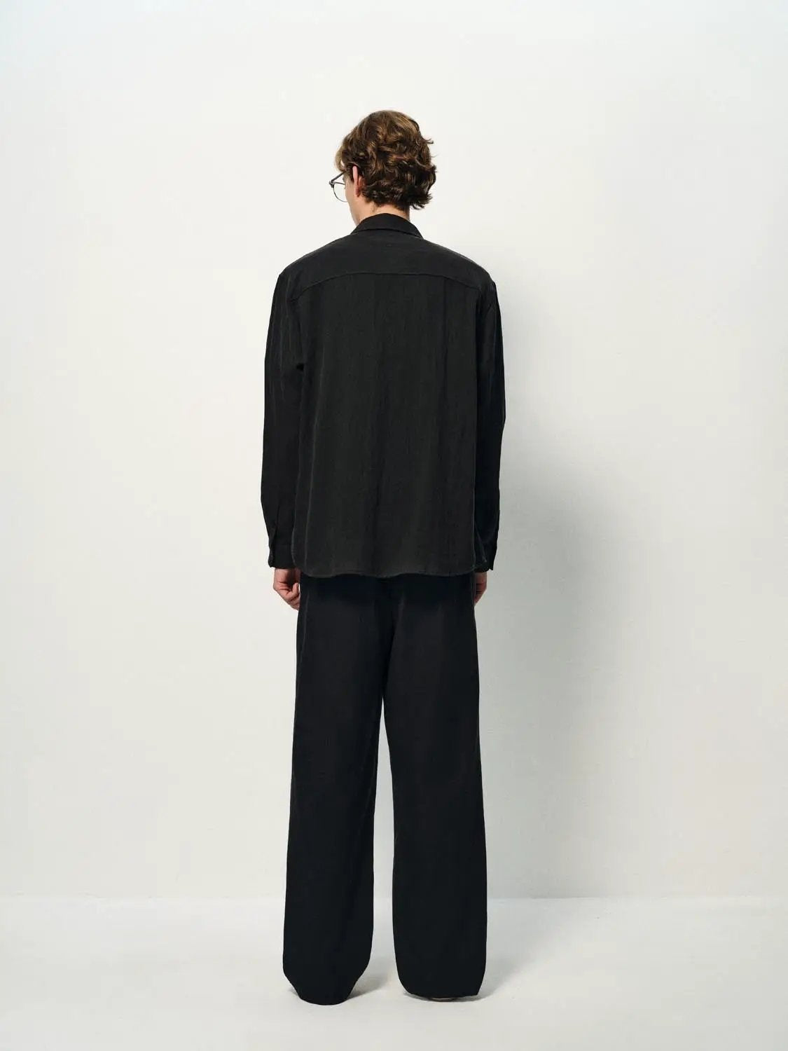 Cardigan Shirt in black, back view of model wearing a long-sleeve top.
