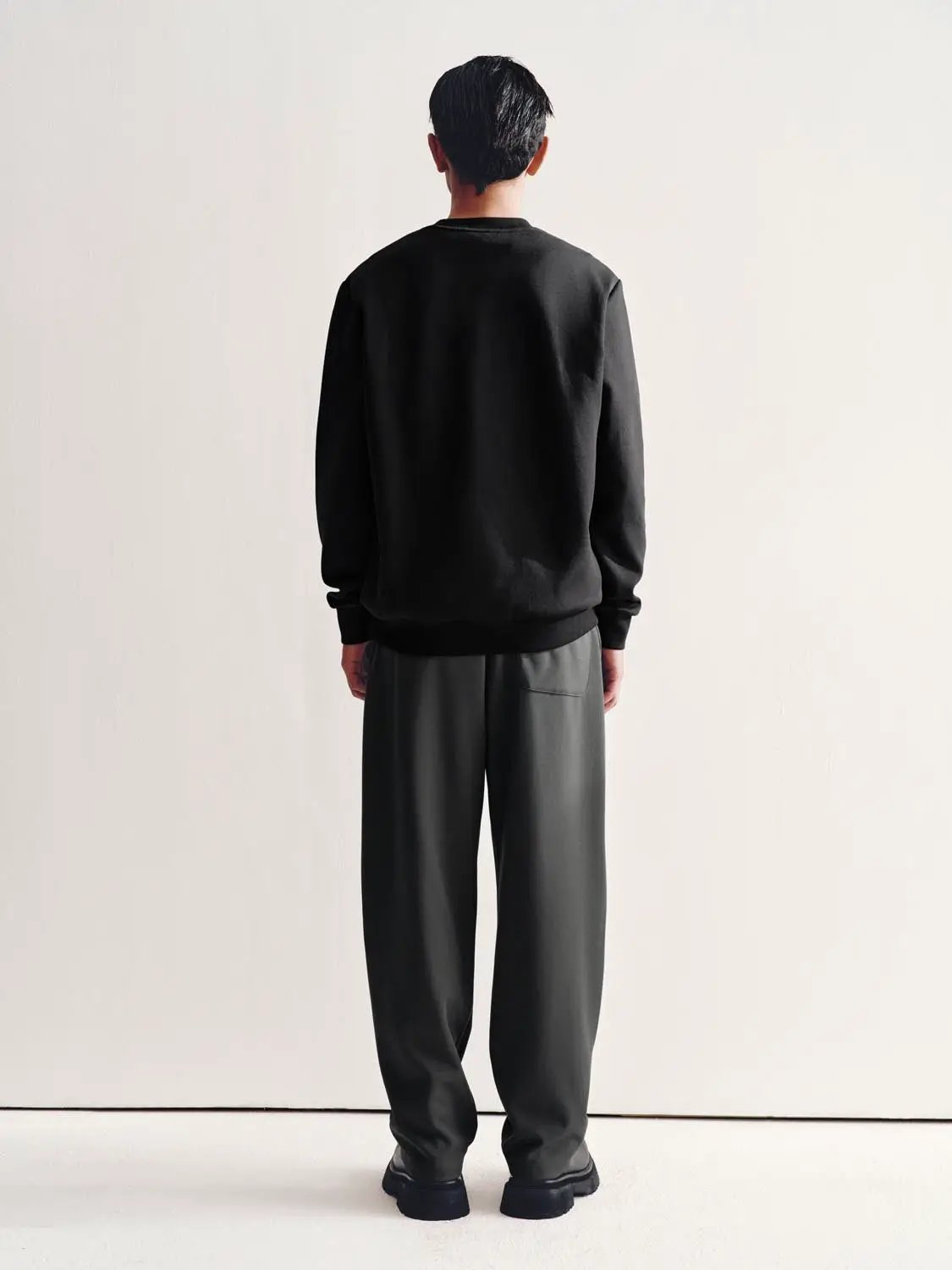 Sweatshirt from Urban Revivo Fashion in black, back view on a model wearing black pants.