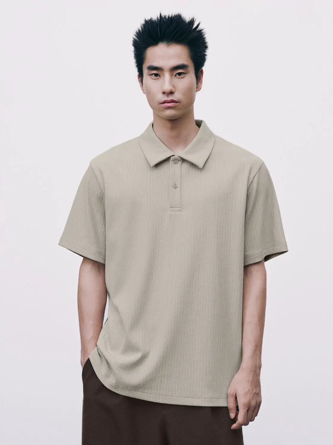 Beige ribbed polo shirt with short sleeves and classic collar.