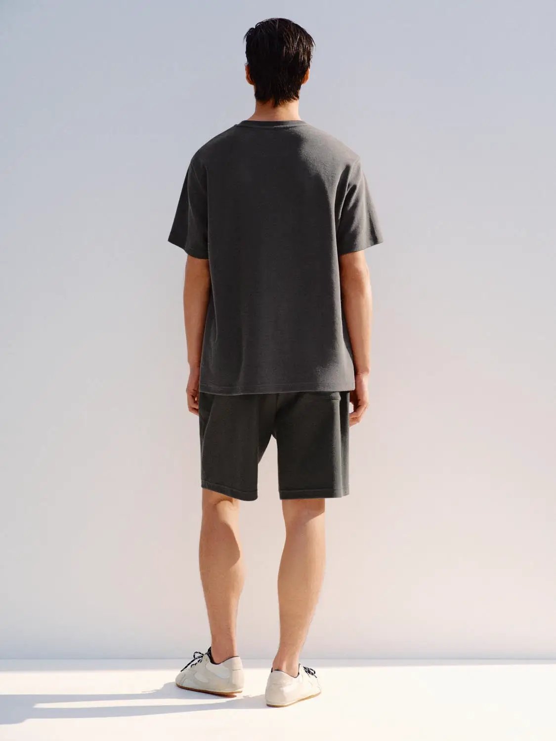 Elastic drawstring waist cotton blend shorts in charcoal gray worn by a man, back view