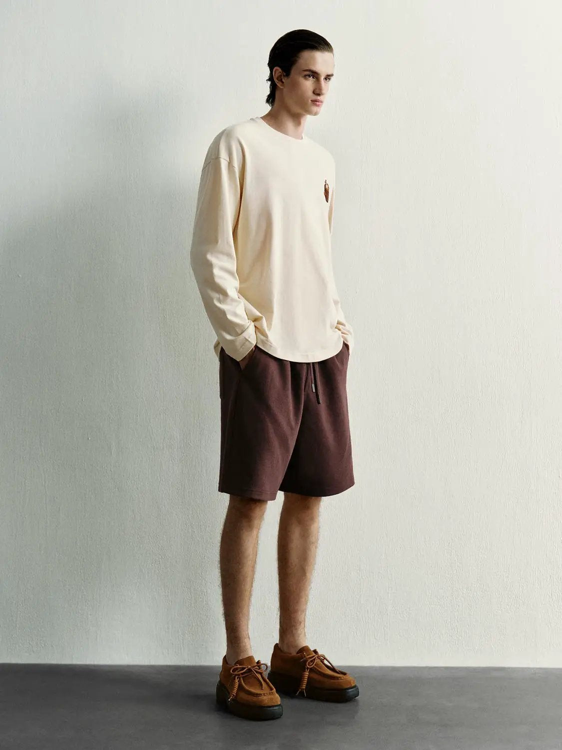 Elastic drawstring waist cotton-blend shorts in brown, shown on a male model with hands in pockets; Urban Revivo Fashion.