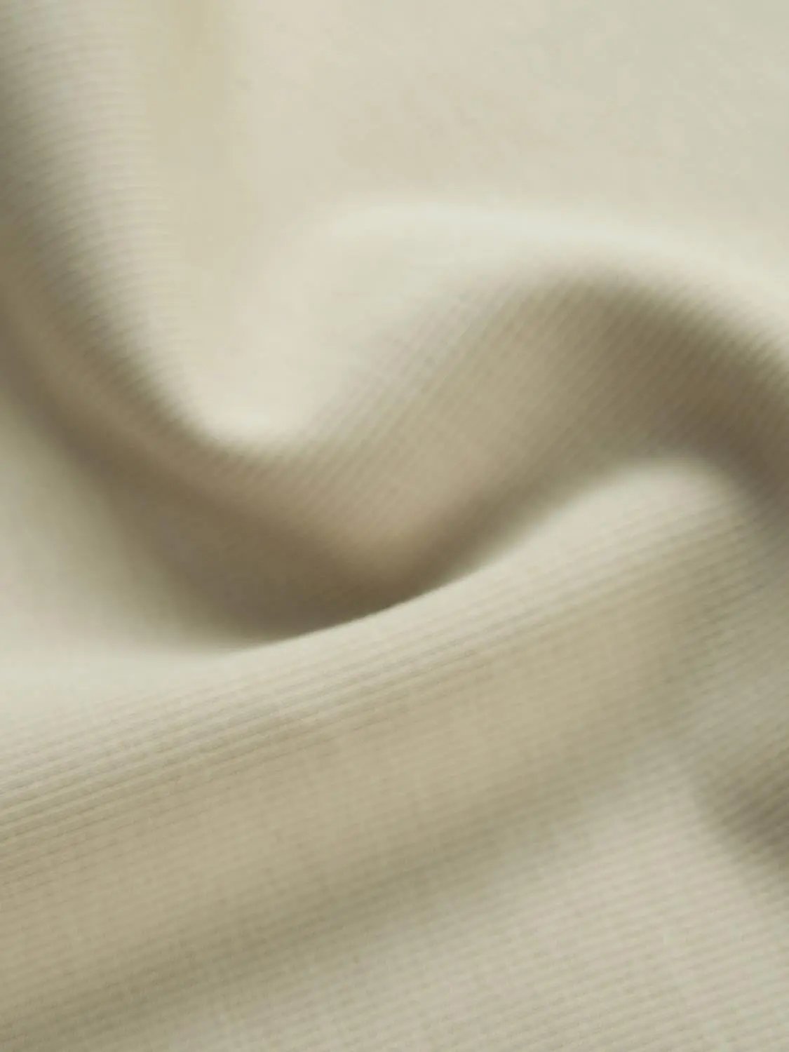 Polo shirts cream fabric close-up texture, soft weave detail.