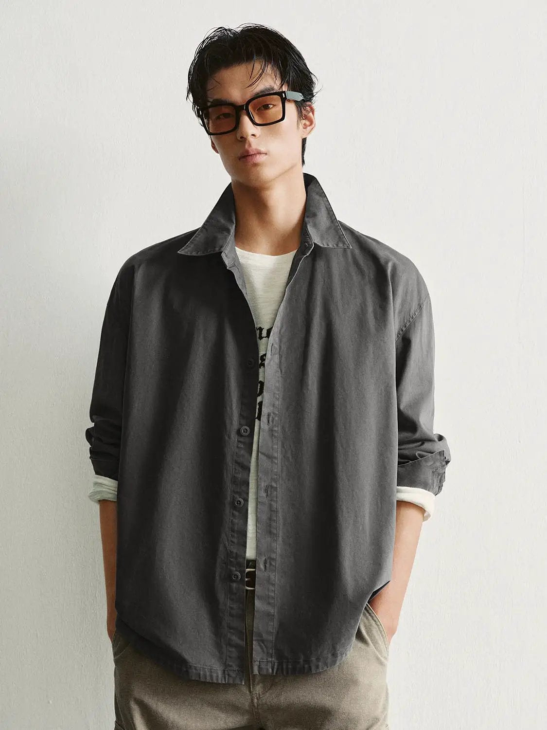 Button-front shirt in charcoal gray with rolled sleeves.
