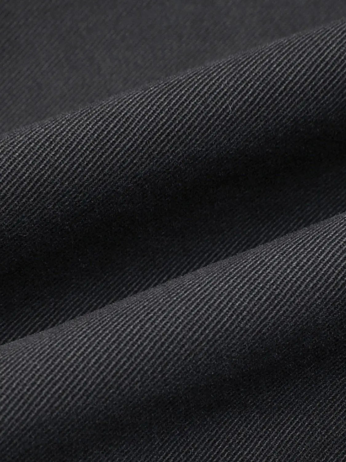 Button-front shirt fabric close-up in dark denim twill