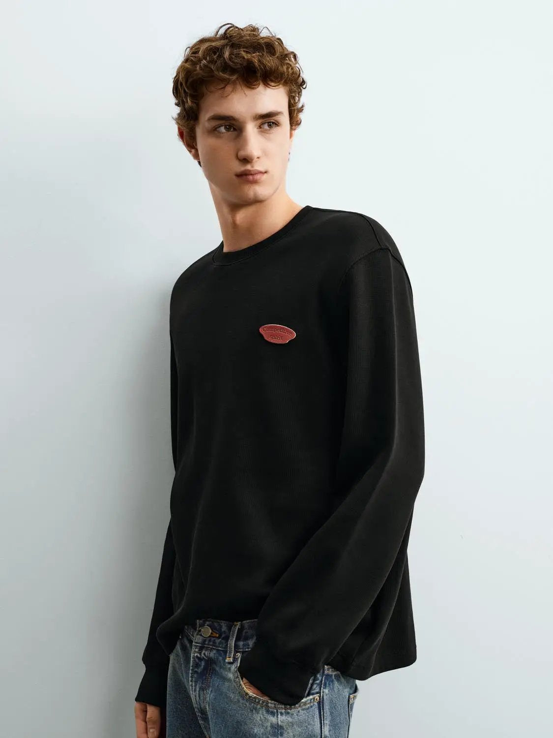Sweatshirt, black crewneck with a small red chest logo.