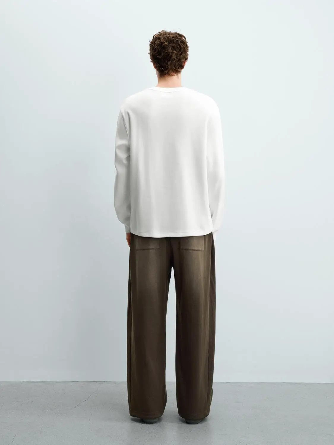 Sweatshirt; white, long-sleeve, worn by model, back view