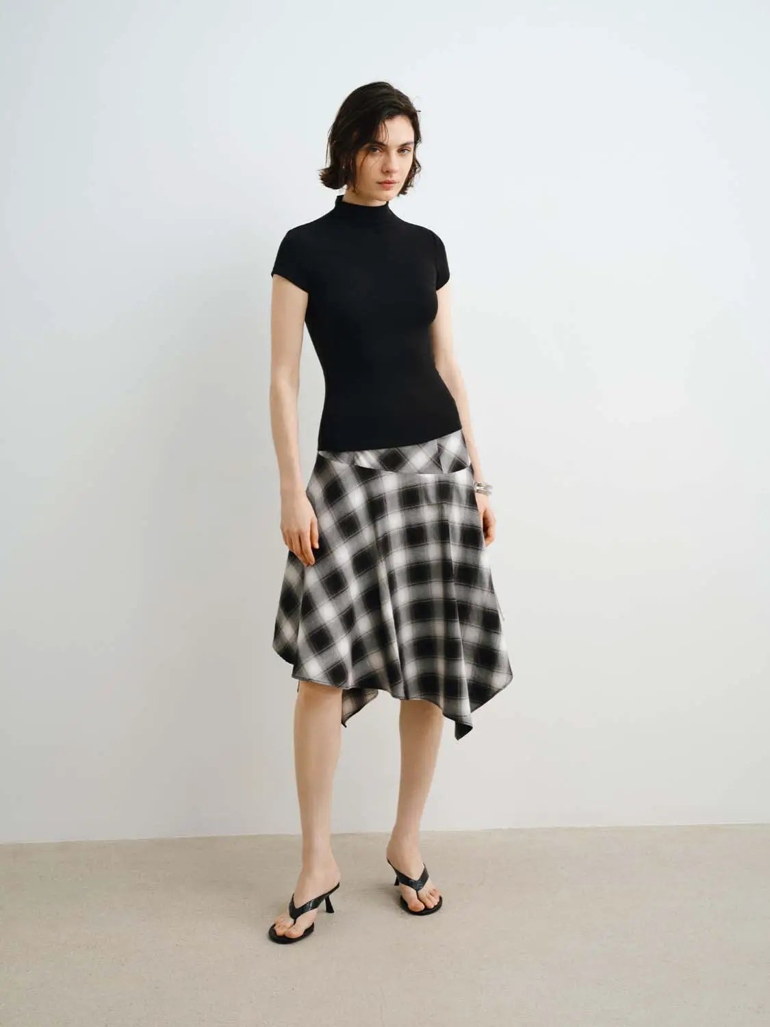 Everyday T-shirts: black modal knit short-sleeve top paired with a black-and-white plaid midi skirt.