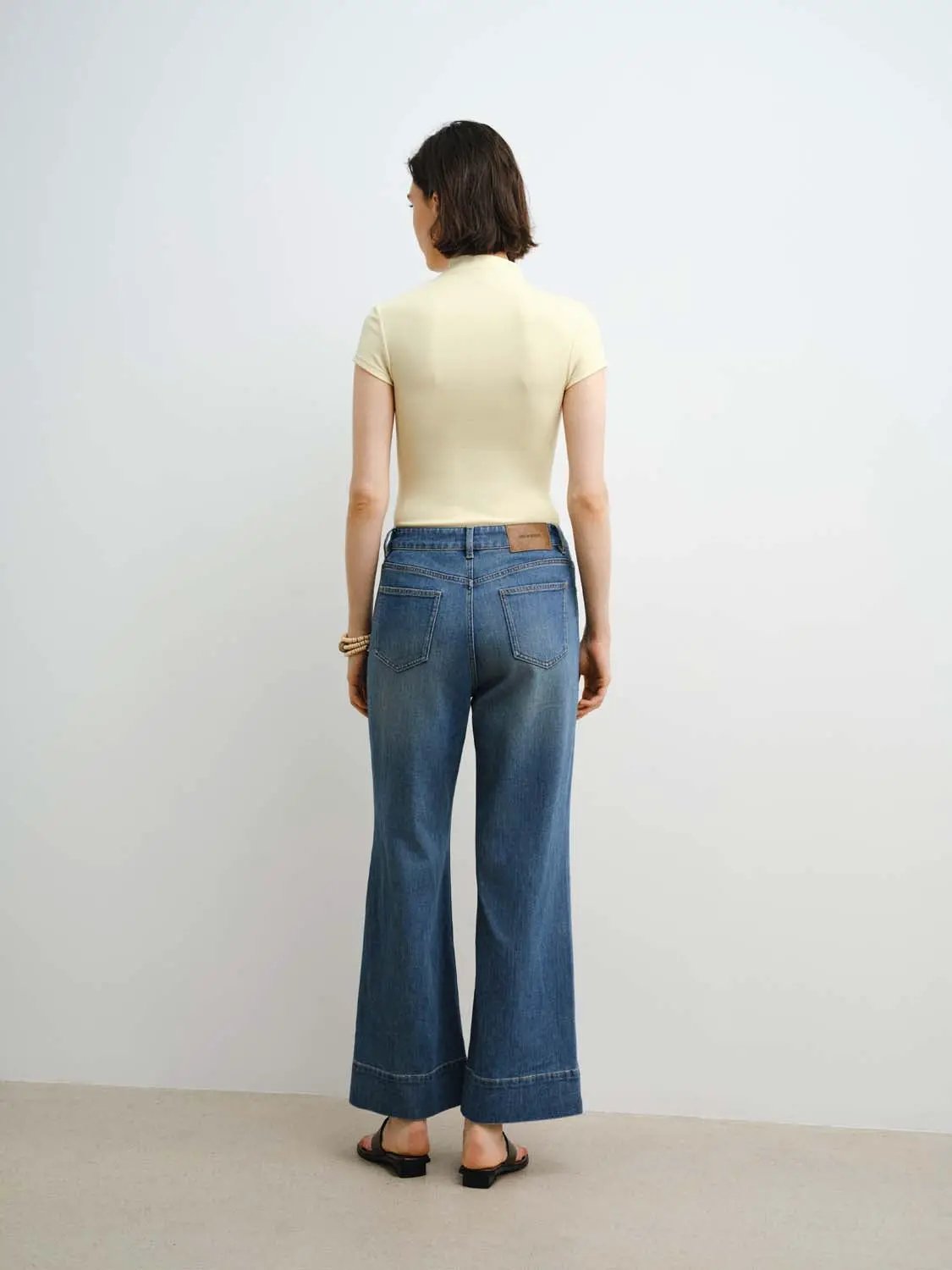 Women's modal knit T-shirt in cream with blue denim wide-leg jeans (back view)