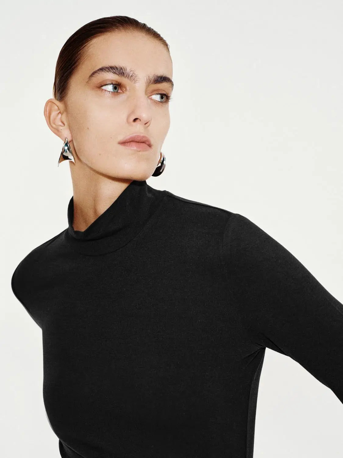 T-Shirt, black mock-neck long-sleeve on model, close-up portrait.