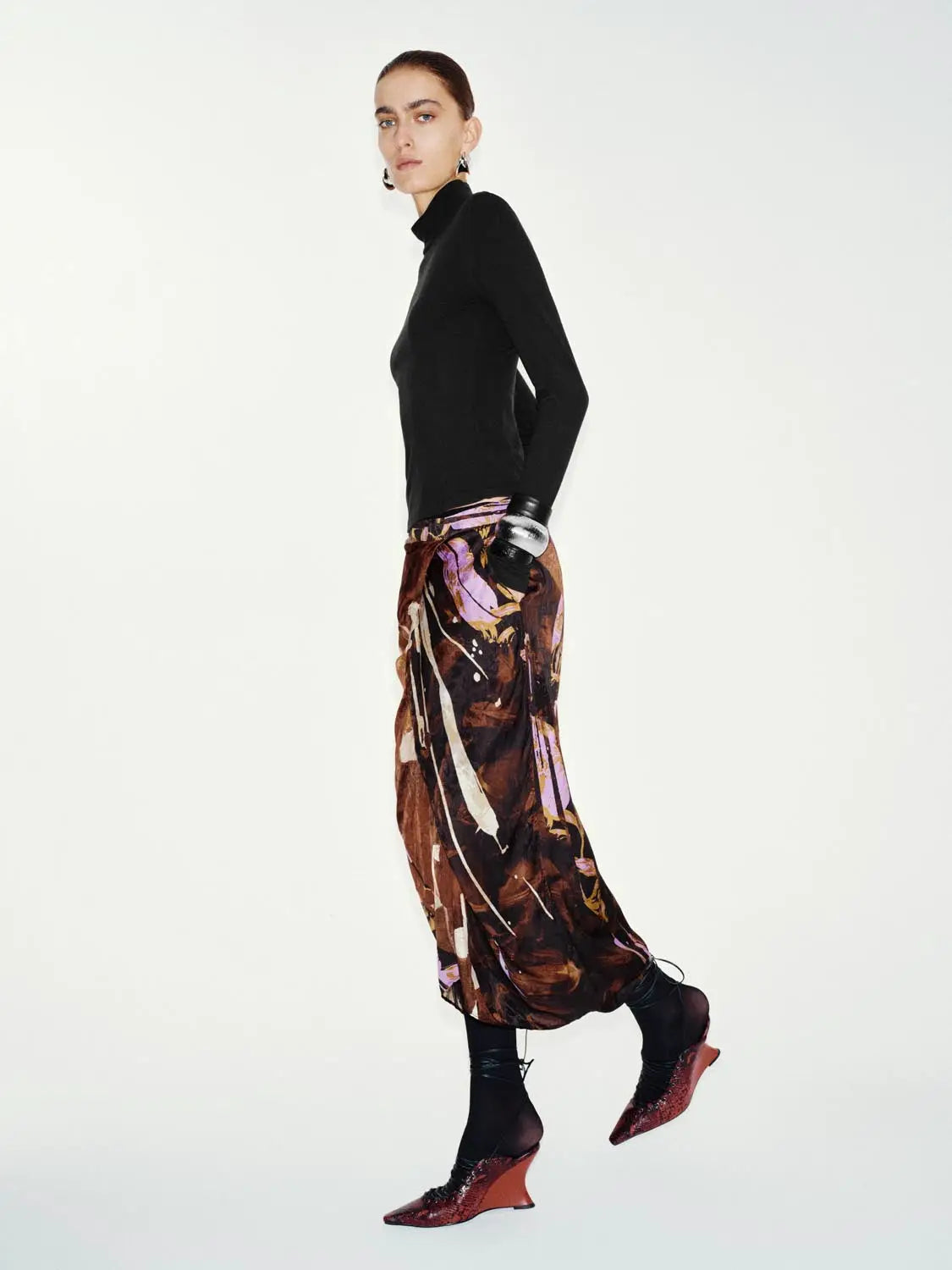 T-Shirt black knit turtleneck top paired with a colorful abstract-print skirt