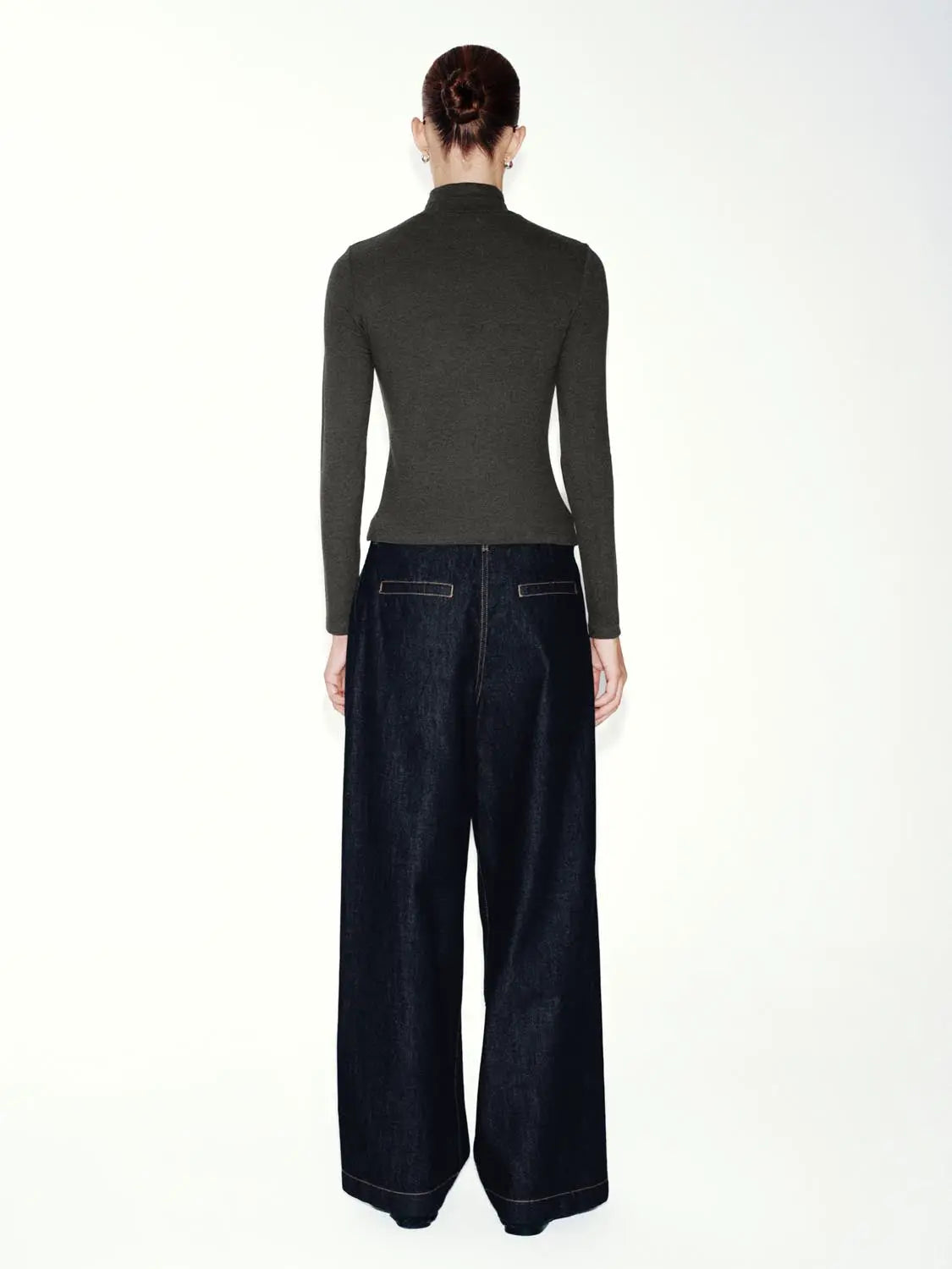 T-shirt in dark grey ribbed knit, back view on model with dark wide-leg jeans