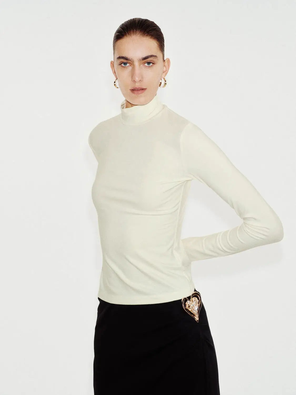 T-Shirt ivory long-sleeve turtleneck by Urban Revivo Fashion; black skirt with heart buckle
