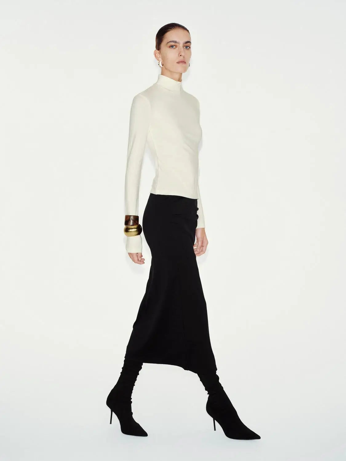 T-shirt, white long-sleeve mock-neck top worn with a black skirt and knee-high boots