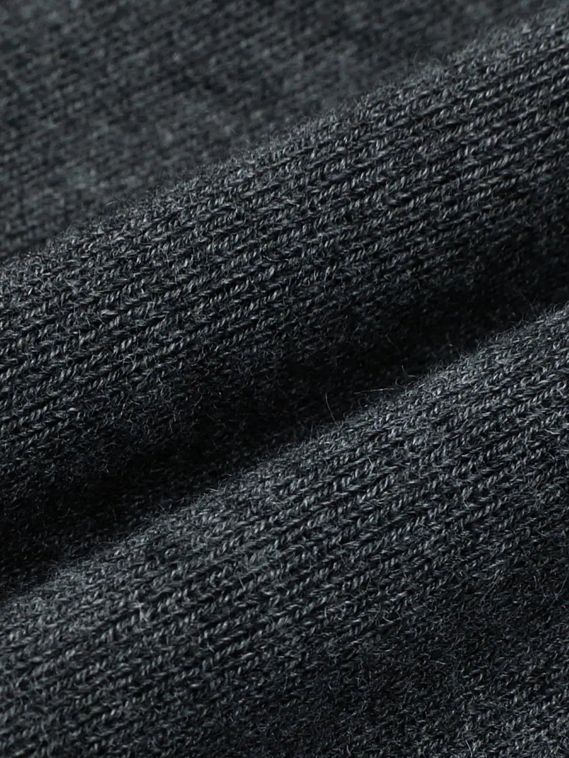 Ribbed fitted mock-neck long-sleeve knit sweater in black; close-up of textured rib knit fabric.
