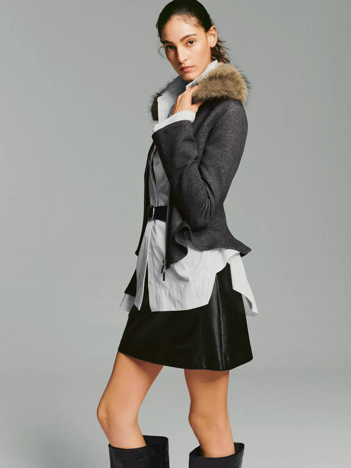 Hoodie jacket in dark gray with a fur-trimmed hood, worn over a white shirt and black skirt