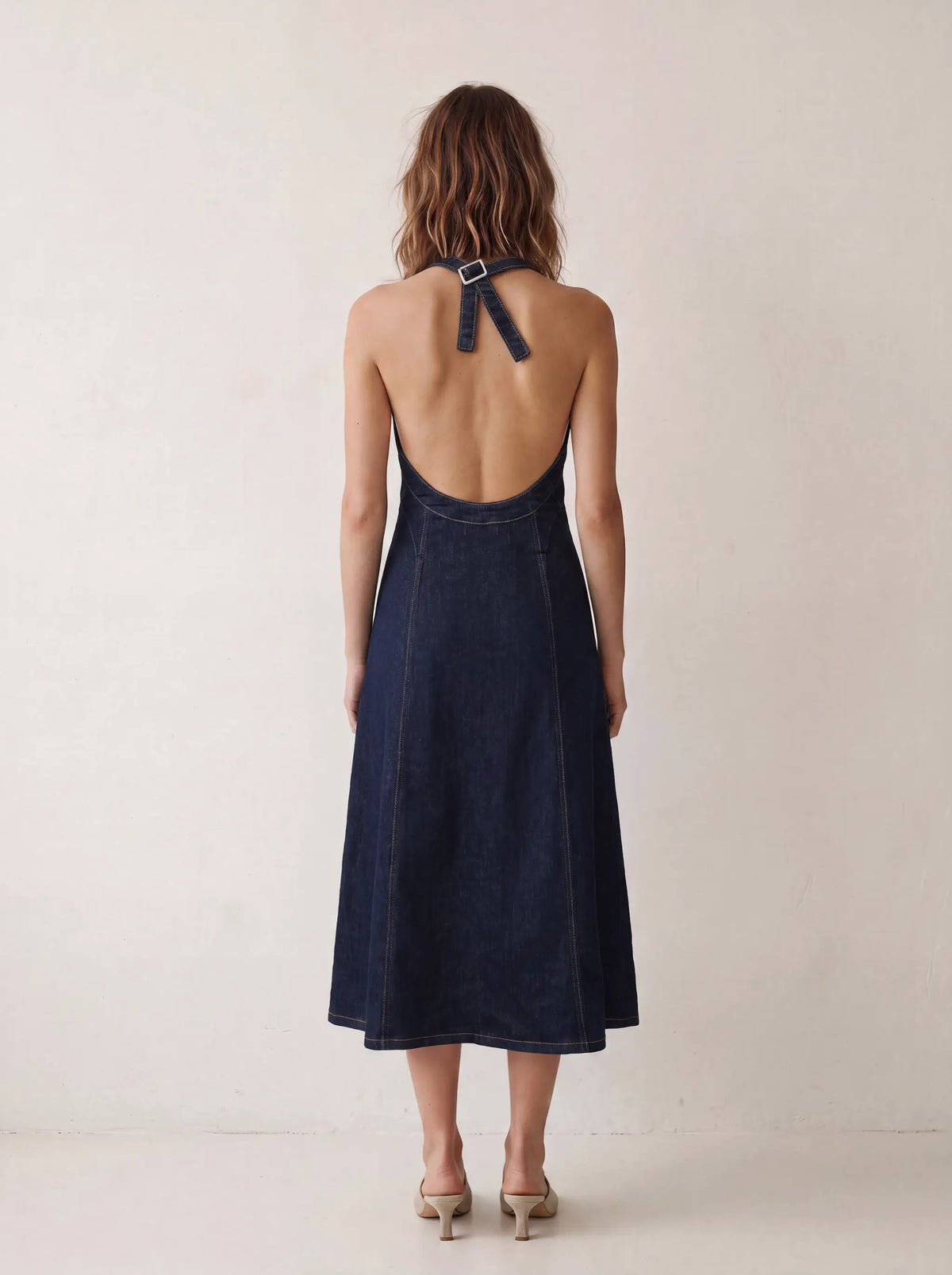 Zipper Front Denim Midi Dress with Panel Seams in indigo denim, back view with halter buckle strap.