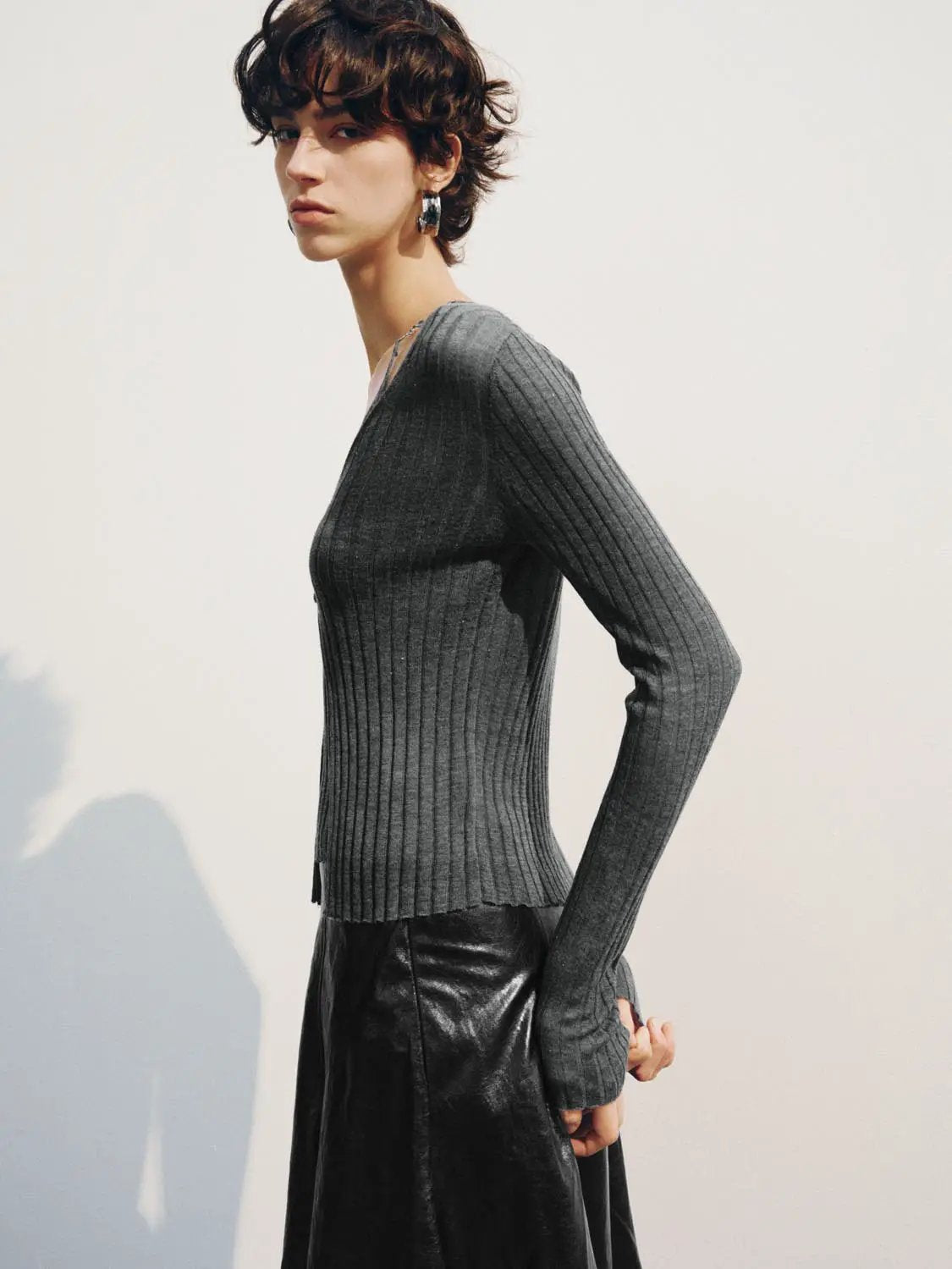 Fitted ribbed V-neck button-front long-sleeve cardigan in gray knit, worn by model.