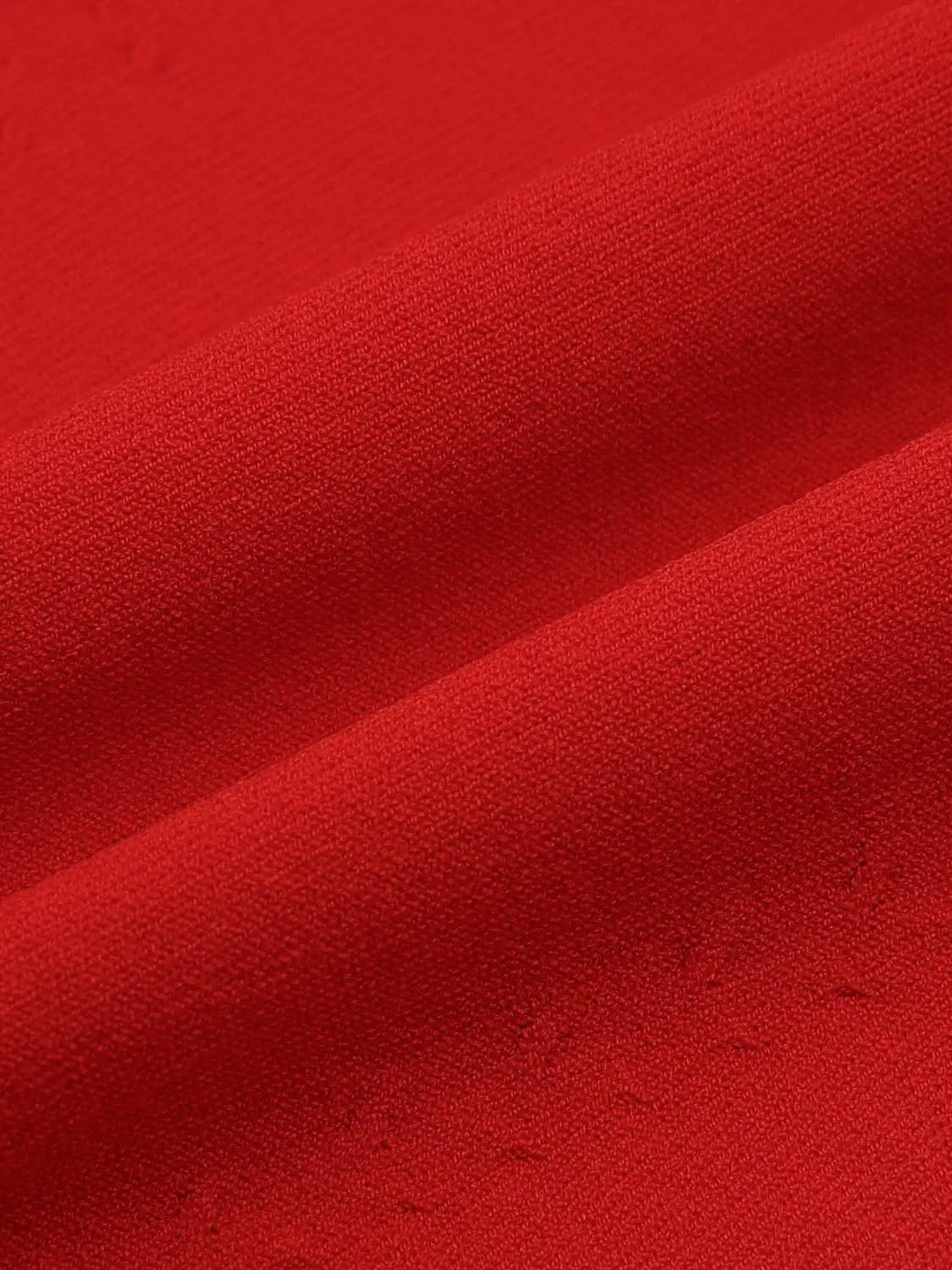 Solid red knitted T-shirt fabric close-up showing knit texture