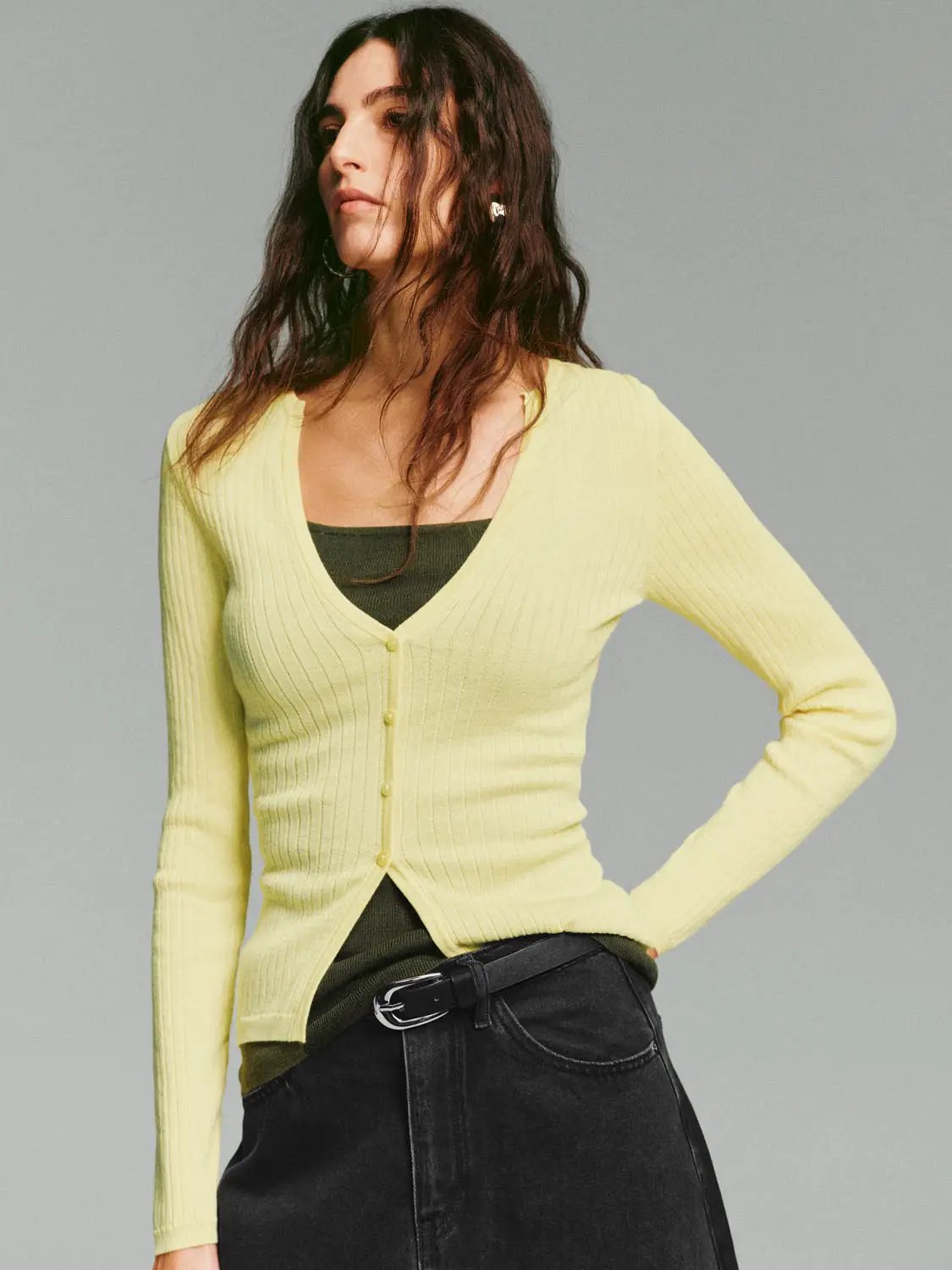 Ribbed yellow cardigan with a V-neck and button-front, long sleeves on a model wearing a dark top