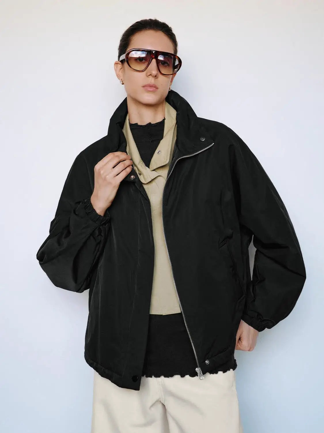 Padded jacket in black with front zipper and elastic cuffs.