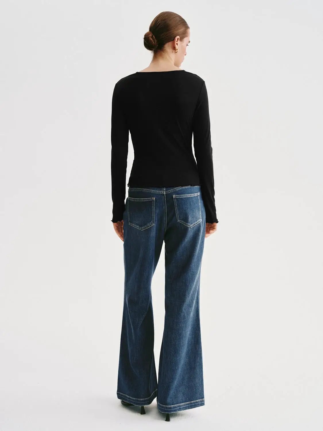 T-shirt, black long-sleeve on model with blue denim jeans, back view