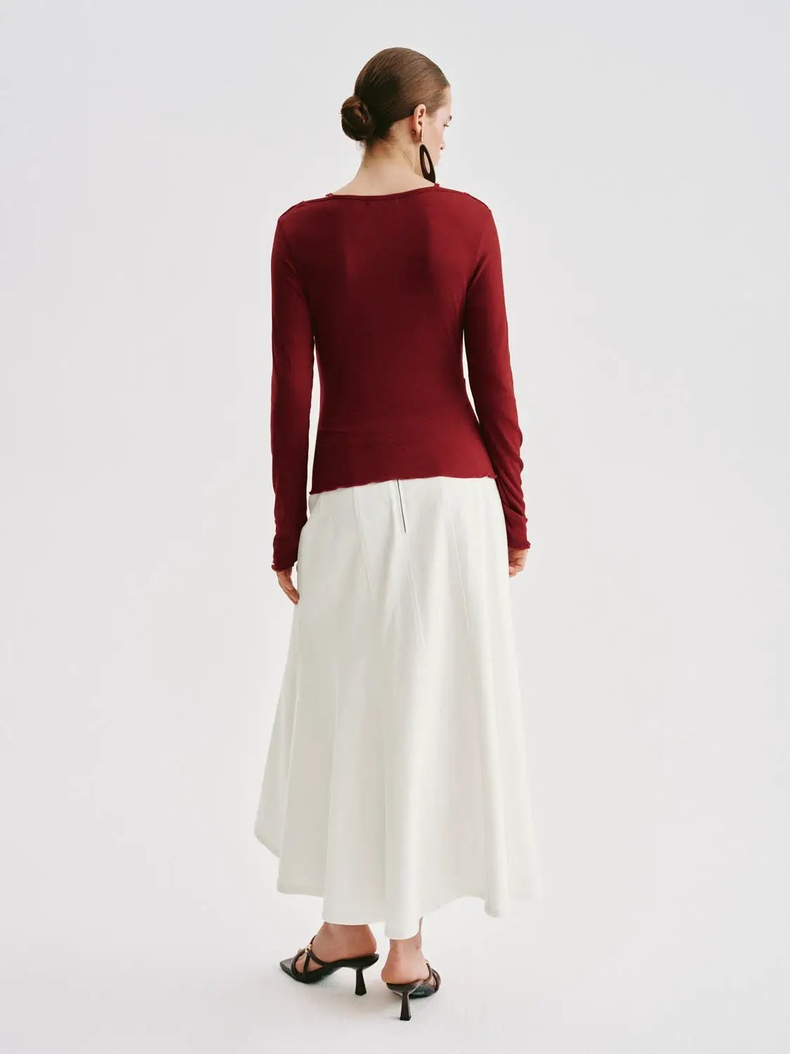 T-Shirt burgundy long-sleeve top with white midi skirt, back view of model