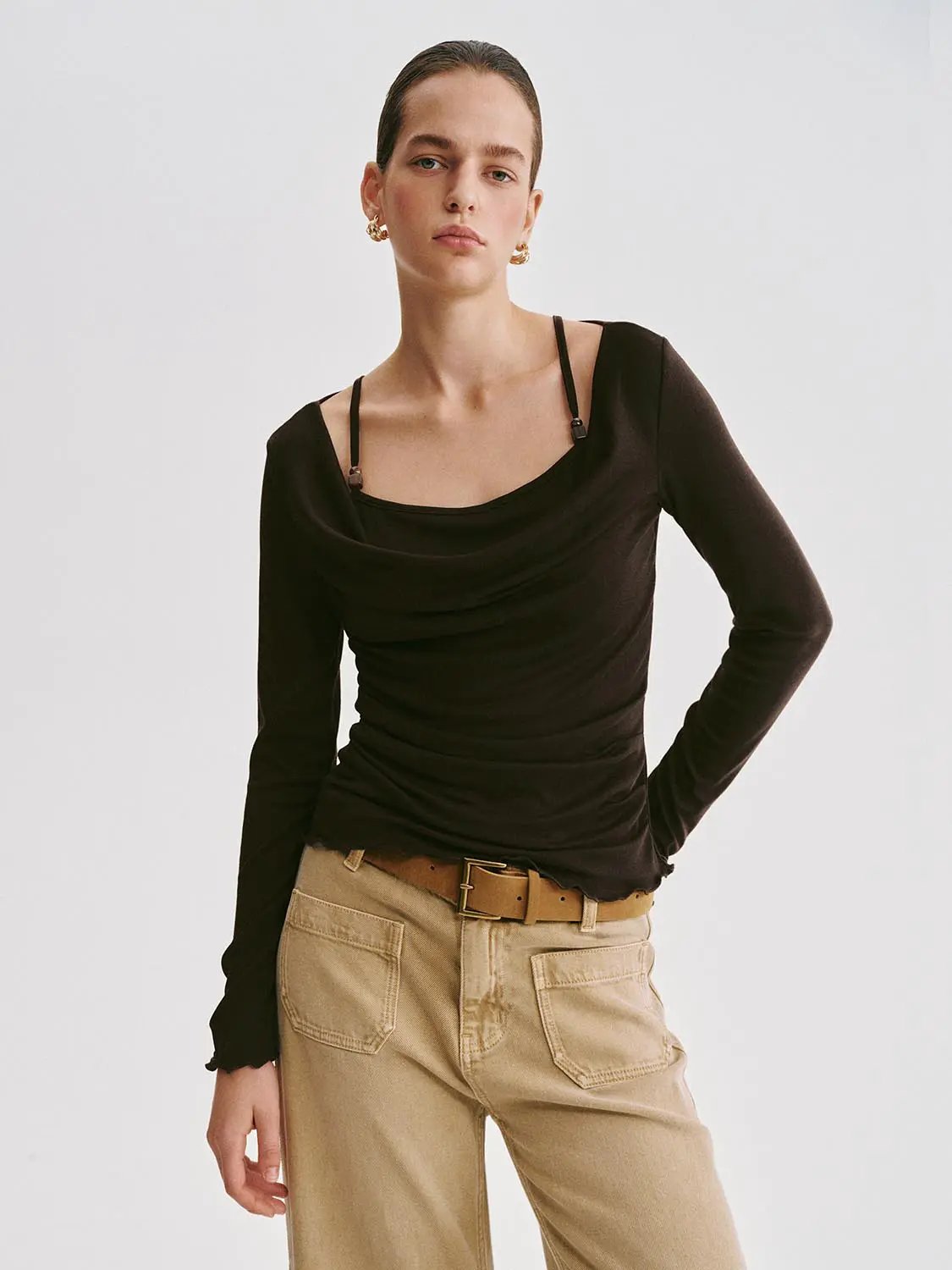 T-Shirt; black long-sleeve top with a draped neckline and ruched waist, paired with beige cargo pants.