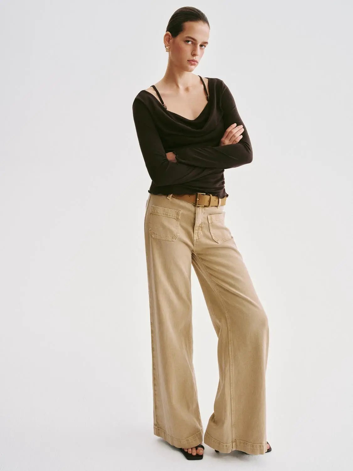 T-Shirt outfit: black draped-neck long-sleeve top with beige wide-leg pants and belt.
