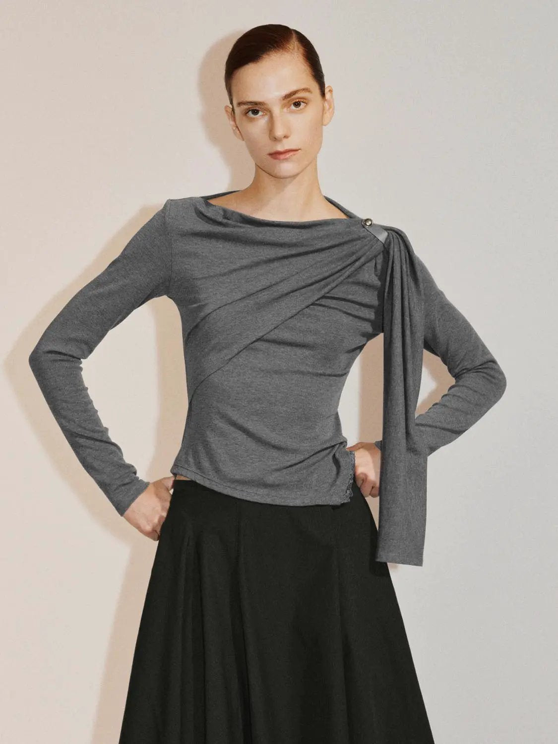 Draped one-shoulder long-sleeve grey blouse with asymmetric shoulder sash.