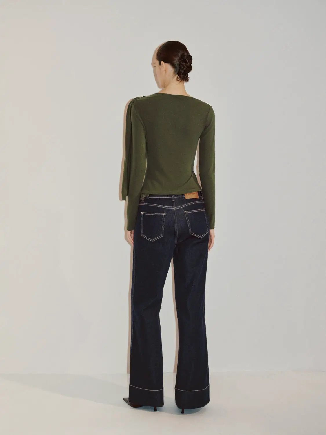 Draped One-Shoulder Long Sleeve Blouse in olive green by Urban Revivo Fashion, back view on model with dark denim jeans.