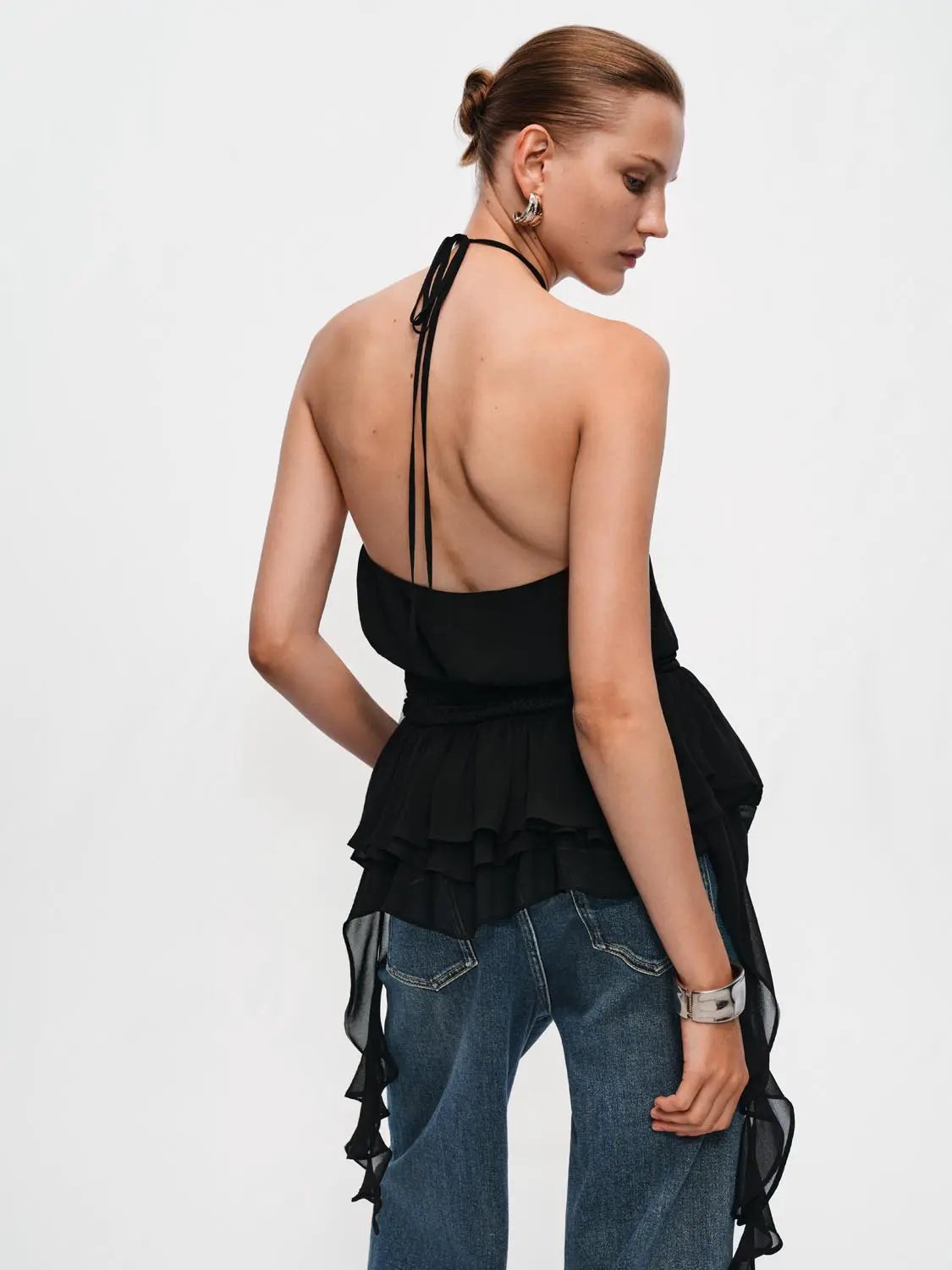 Black halter-neck evening A-line dress with tiered ruffle layers and open-back design.