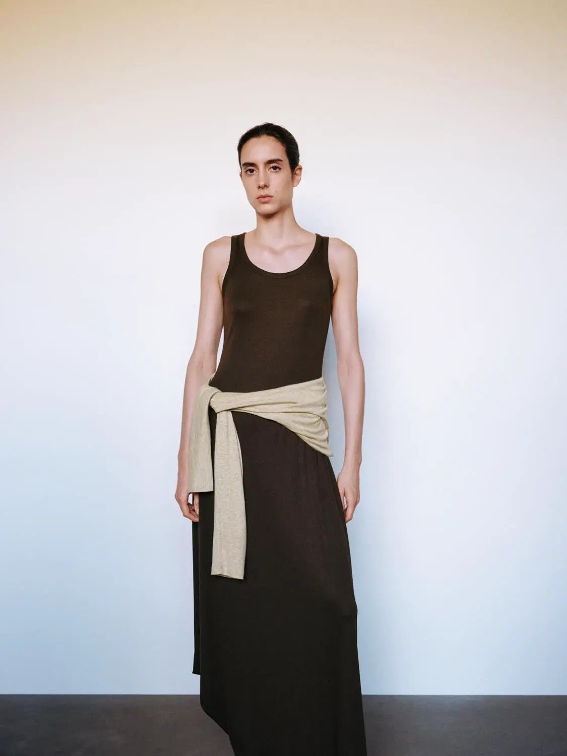 W_A-Line maxi dress in chocolate brown, sleeveless, with beige knit sweater tied at the waist.