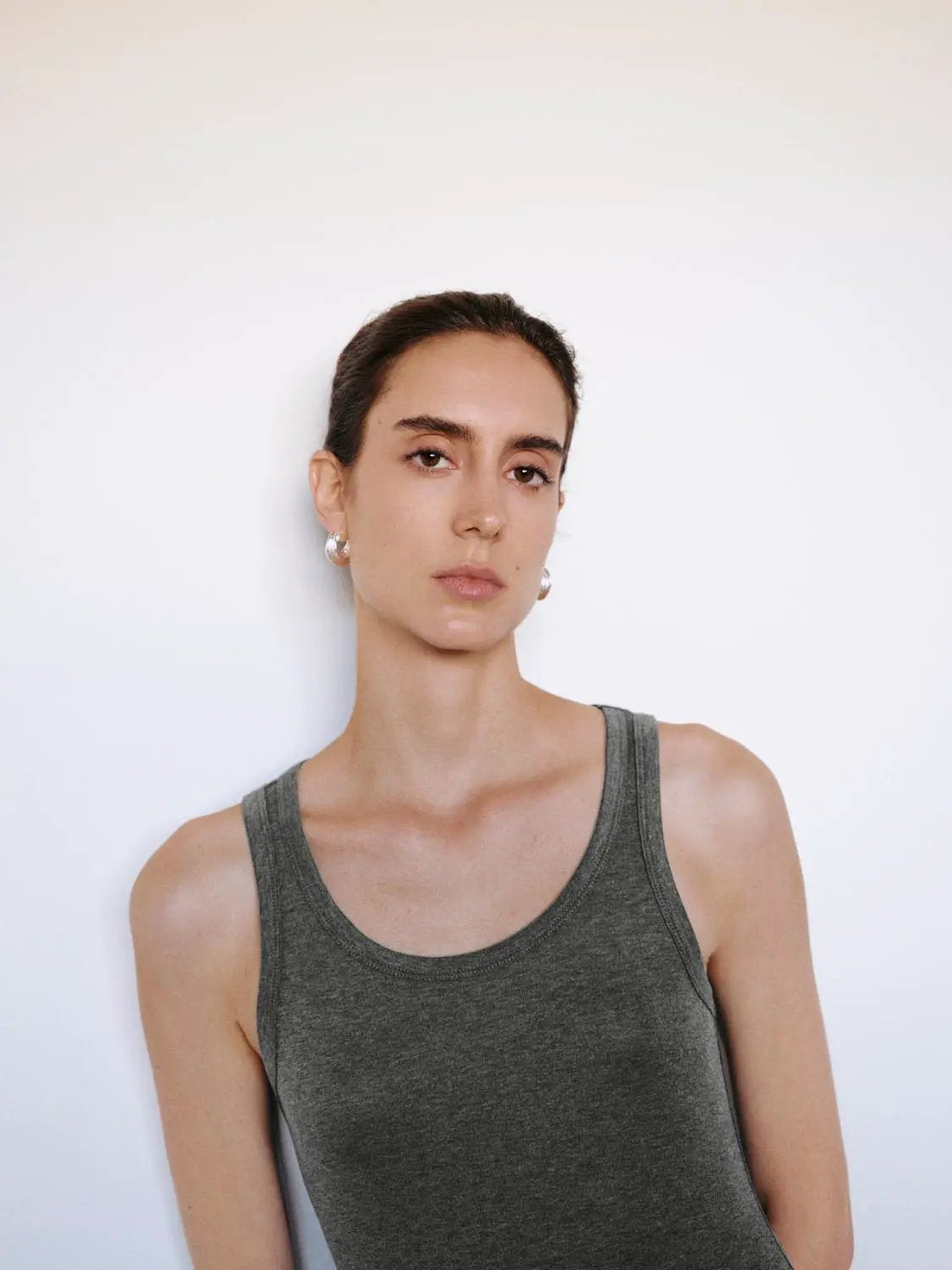 Tank top on model in gray sleeveless ribbed knit, casual wear.