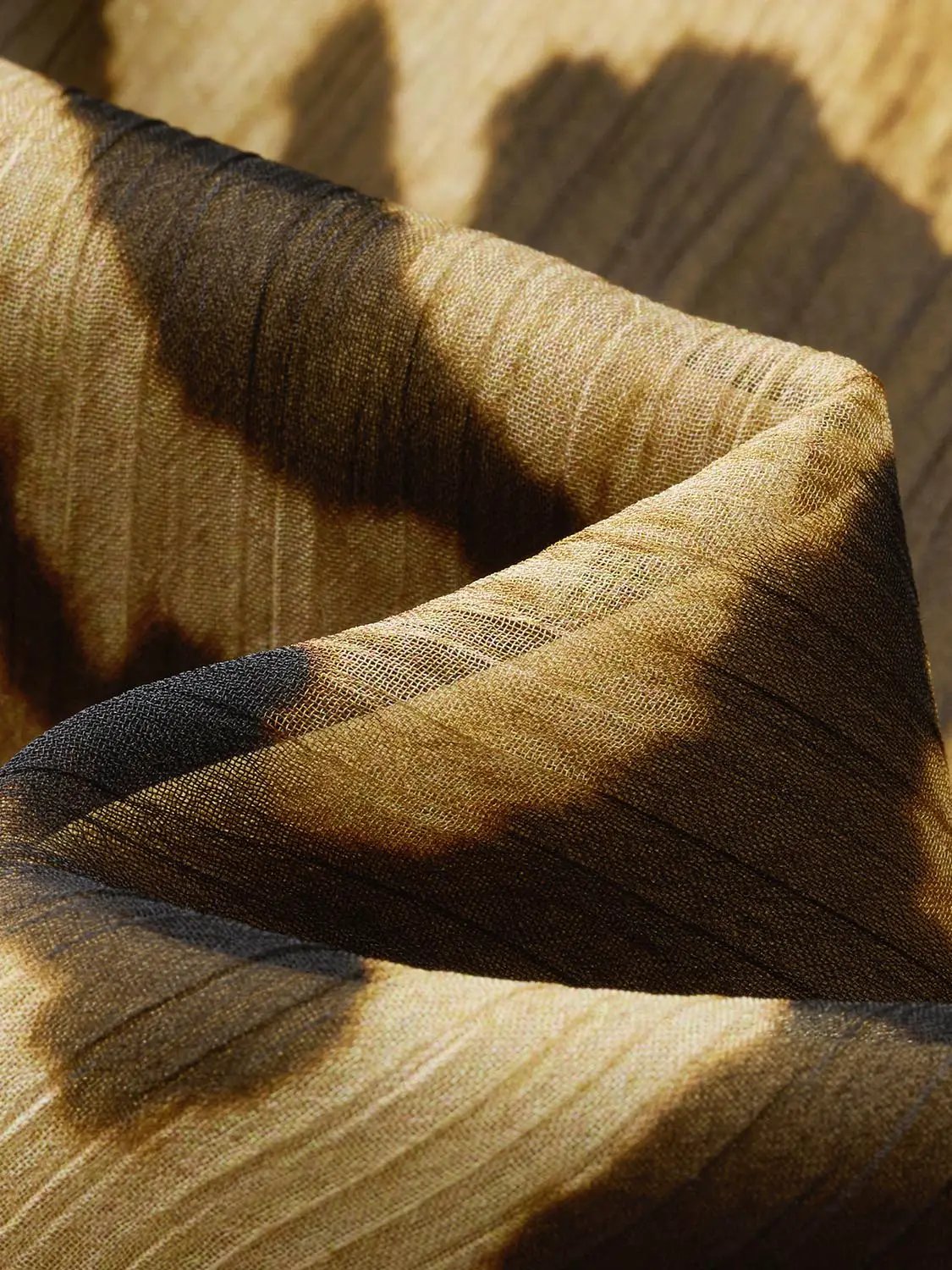 A-line dress fabric close-up in golden bronze satin with striped weave.