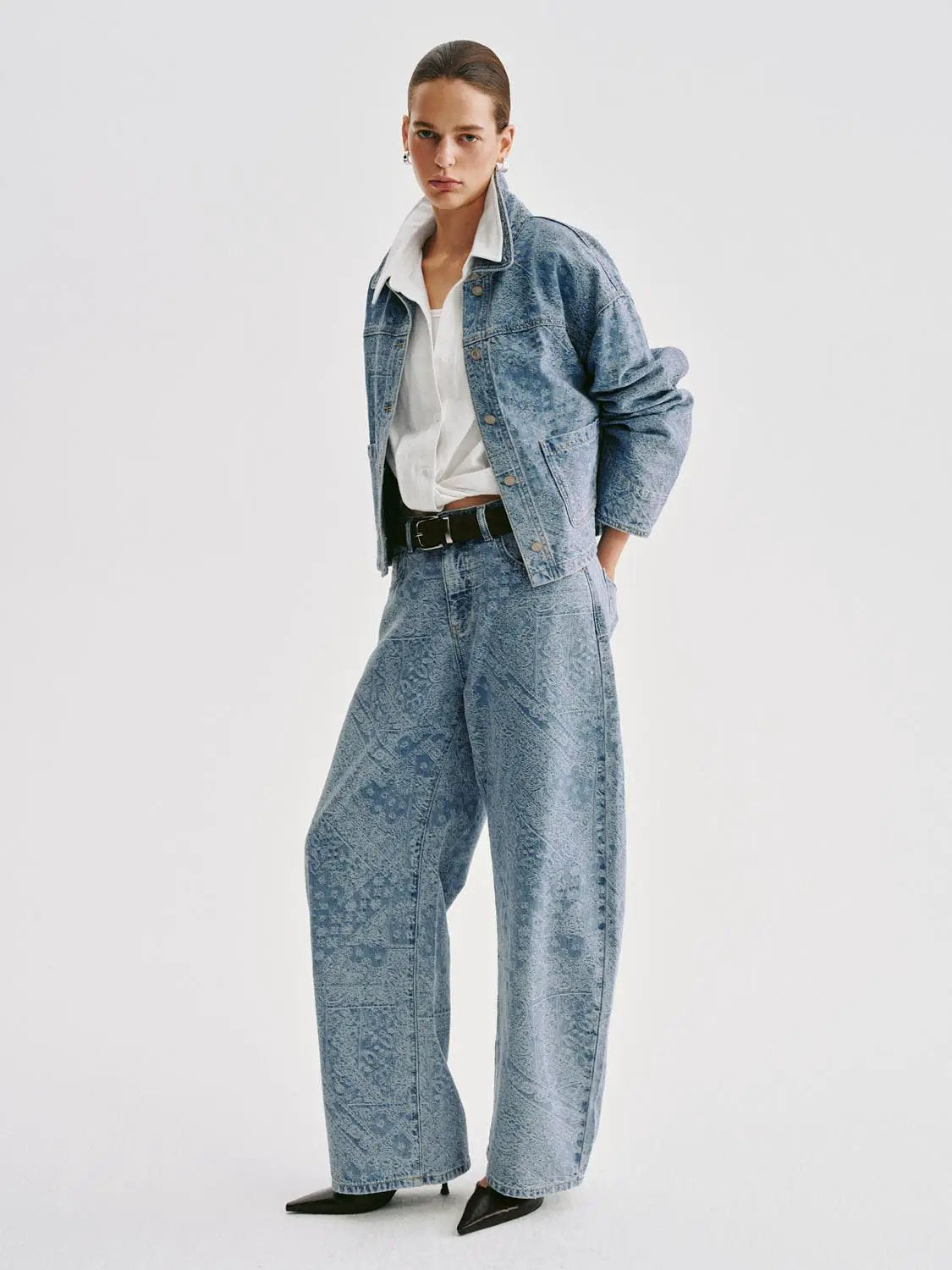 Denim jeans in light-wash blue with a wide-leg fit, modeled with a denim jacket