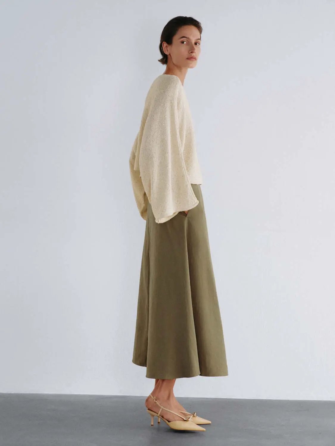 Oversized cropped textured knit sweater with boat neck and drop shoulders in cream.