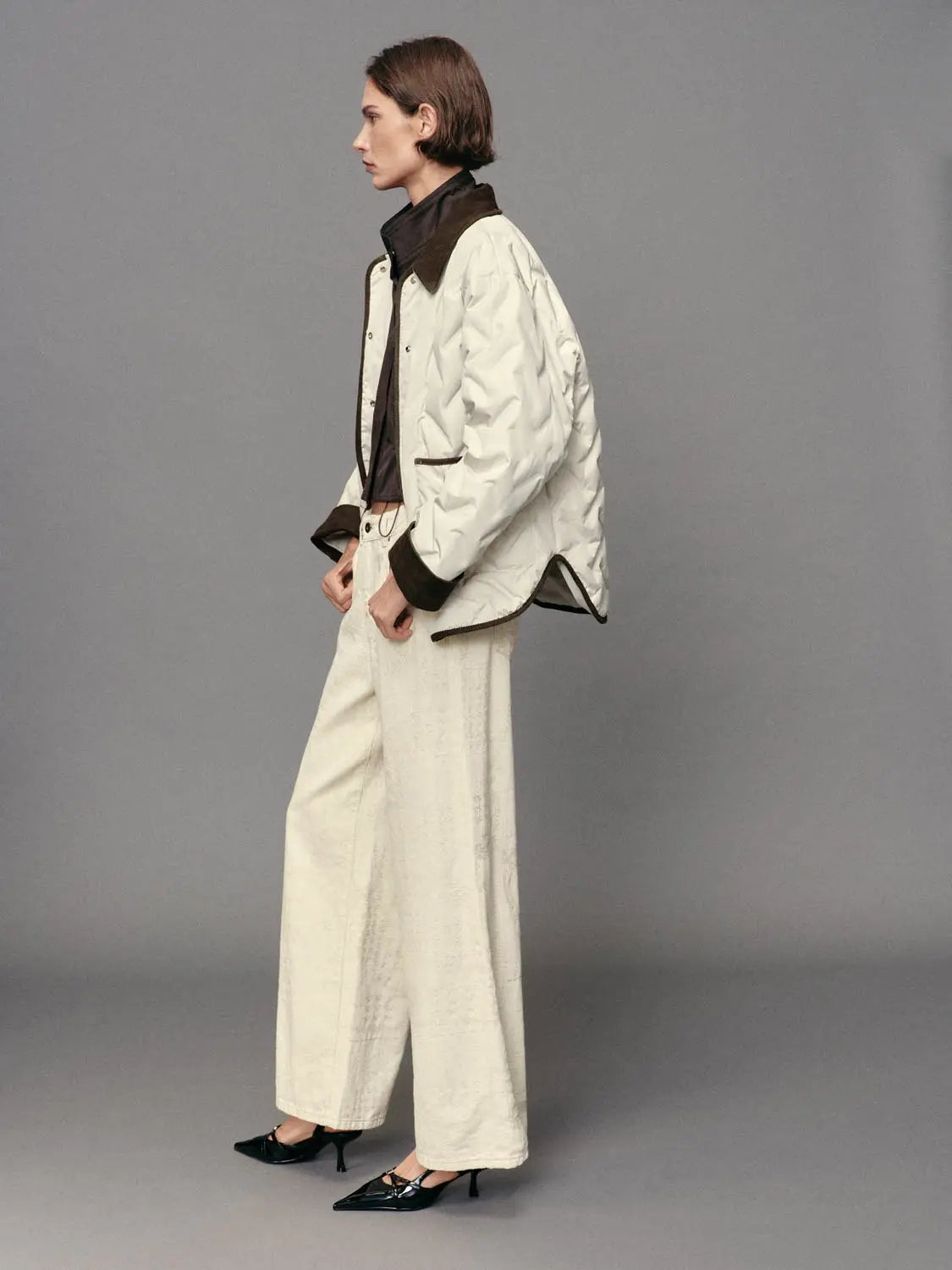 Down jacket cream quilted with brown collar and cuffs, paired with cream wide-leg pants.