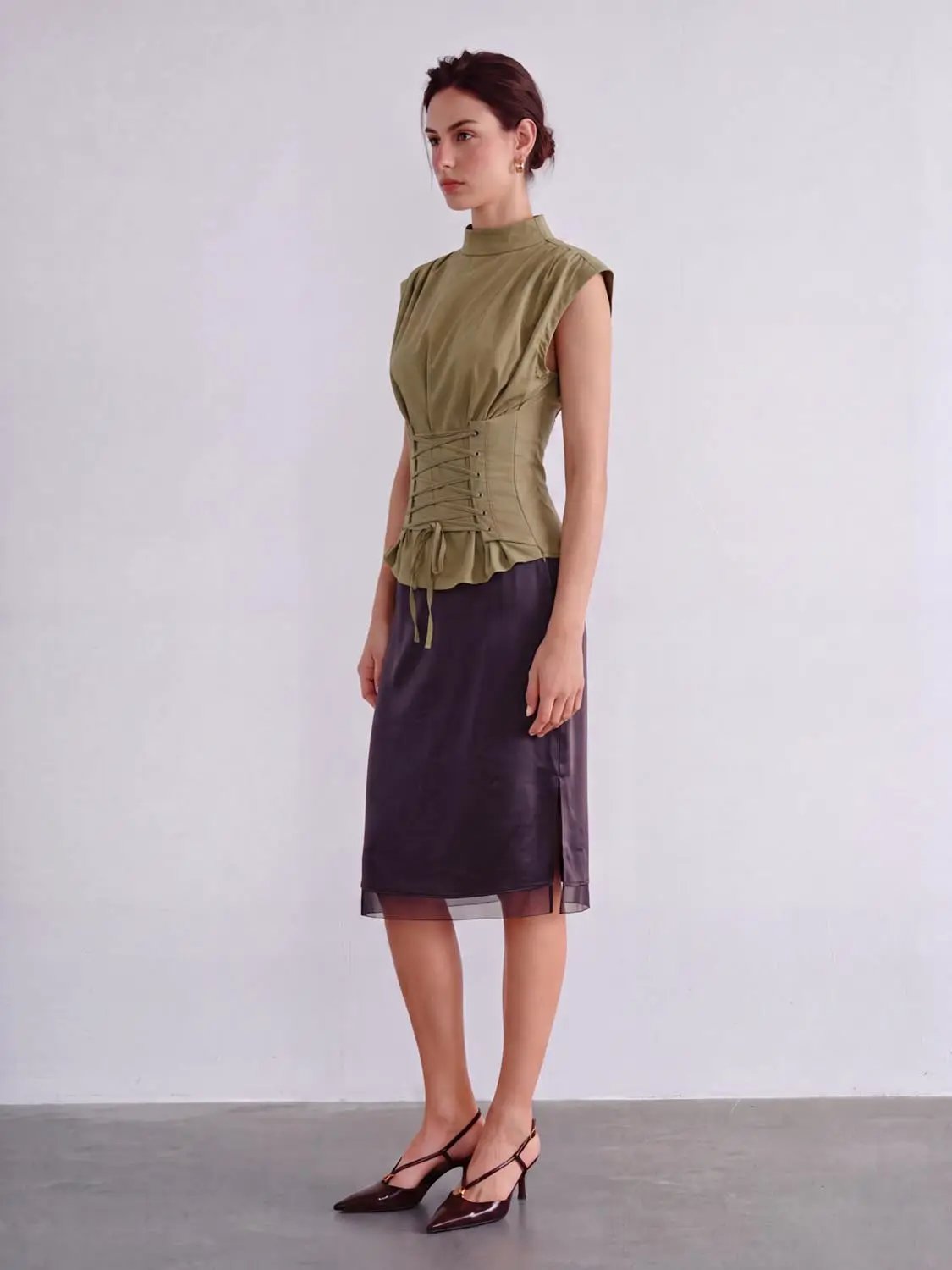 Blouse olive green sleeveless top with corset lace-up waist and ruffled peplum hem.
