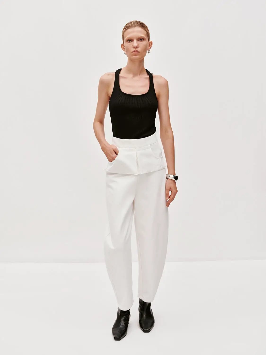 Layered overlay draped waist wide-leg cotton trousers in white with curved-leg silhouette.
