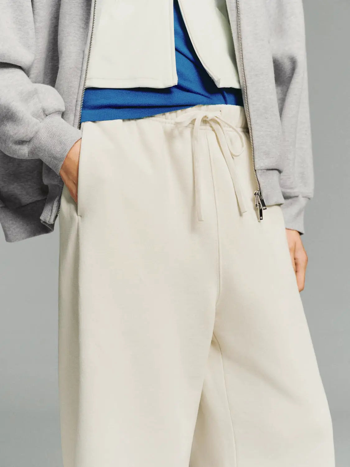 Wide-leg pants in cream with drawstring waist and side pockets.