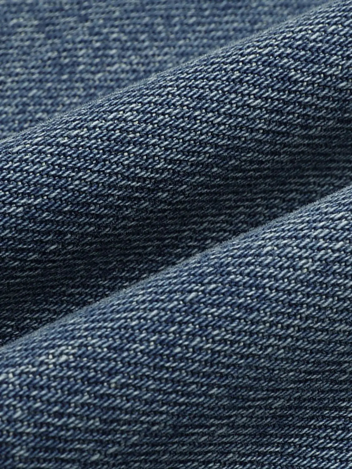 Jeans in blue denim fabric close-up texture showing twill weave