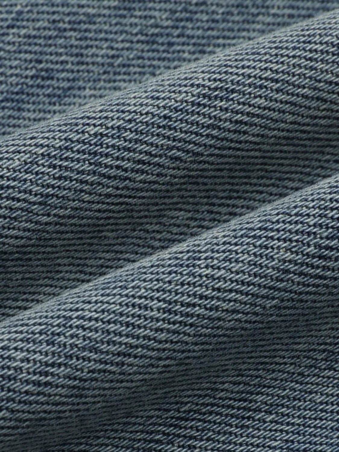 Jeans blue denim fabric close-up showing twill weave texture