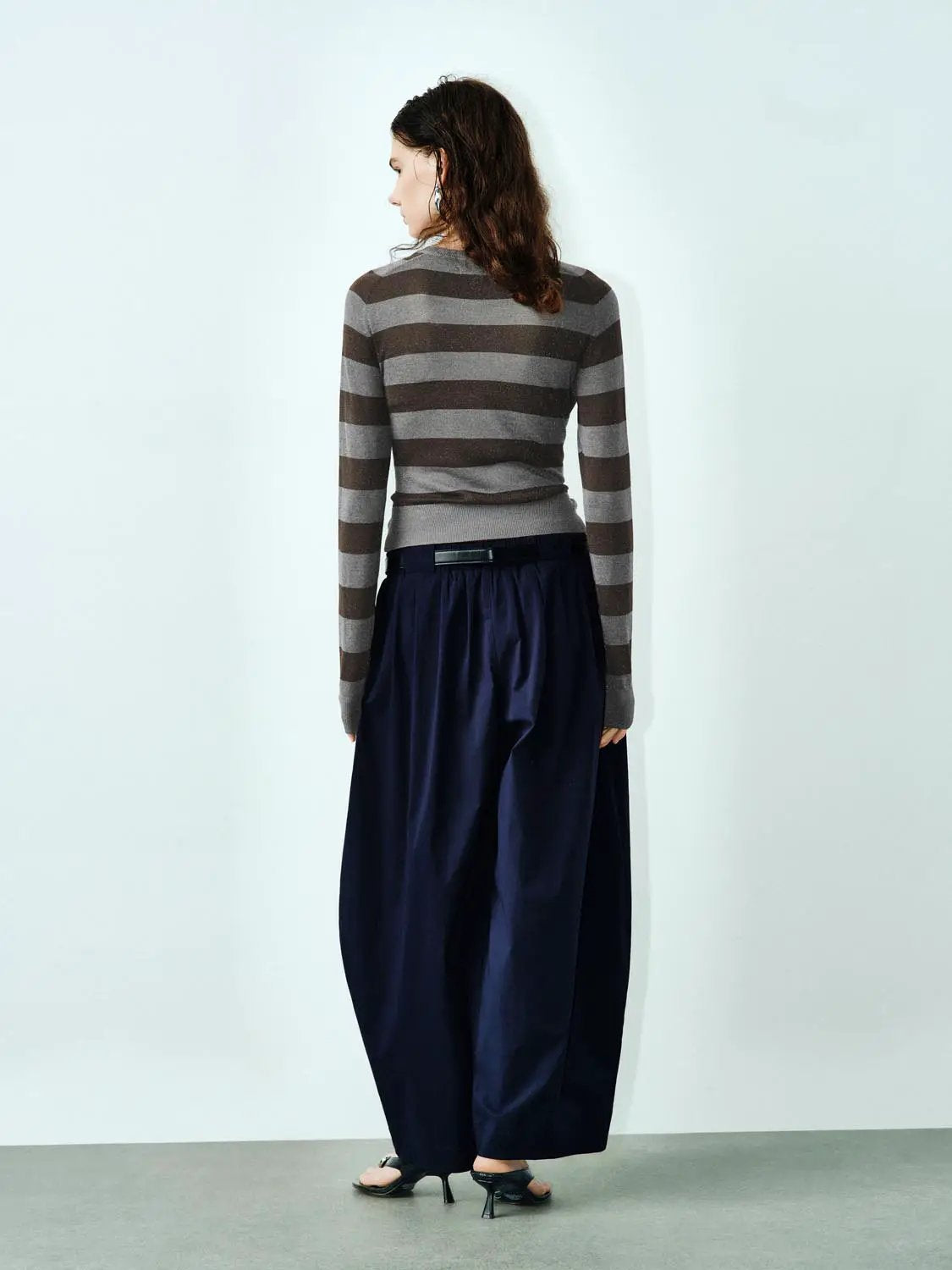 Knitted Cardigans gray and brown striped, long-sleeve on model in navy wide-leg pants.
