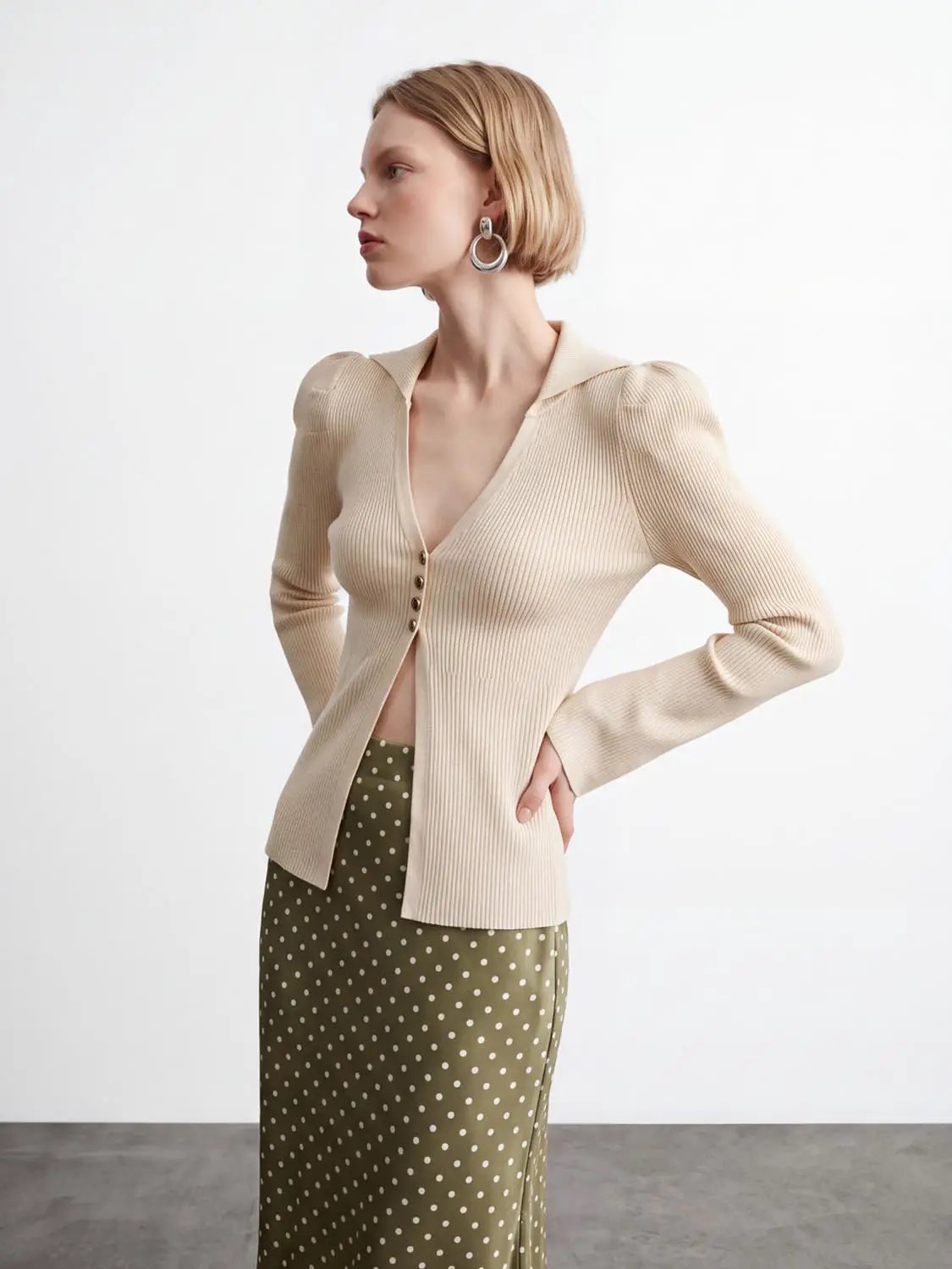 Puff shoulder tailored knitted cardigan in beige ribbed knit with front buttons.